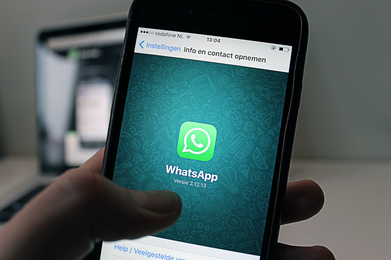 Kuvassa näkyy puhelin, jossa on WhatsApp-sovellus käynnissä, mahdollistaen tekstiviestien lähettämisen ja videopuhelut